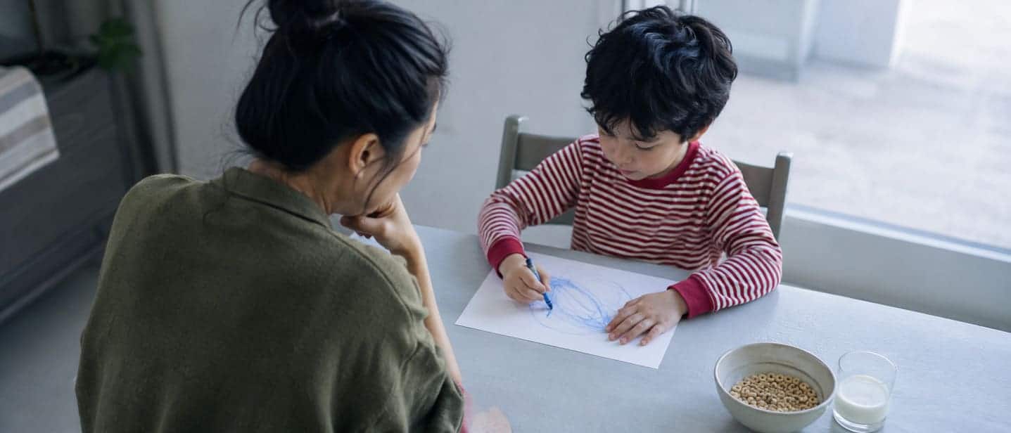 A parent listening to a child at a kitchen table