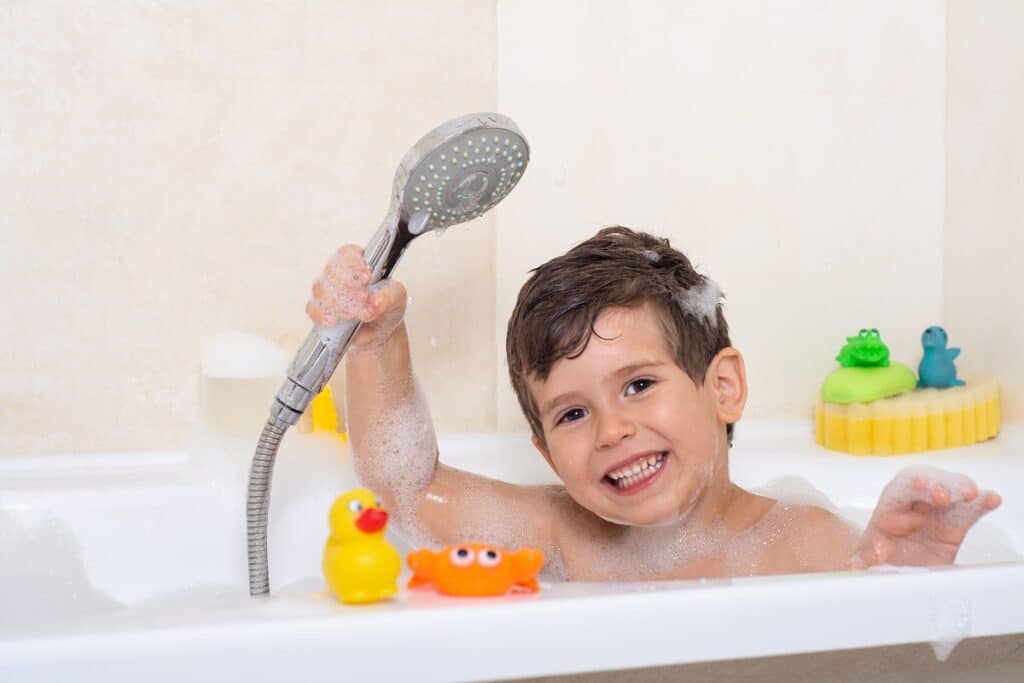 kid taking bubble bath. child bathing in bathtub. little boy pla