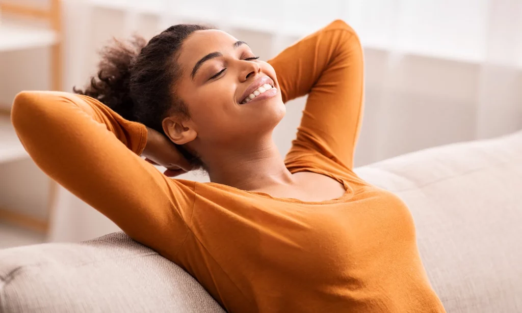 smiling young woman on couch leans back