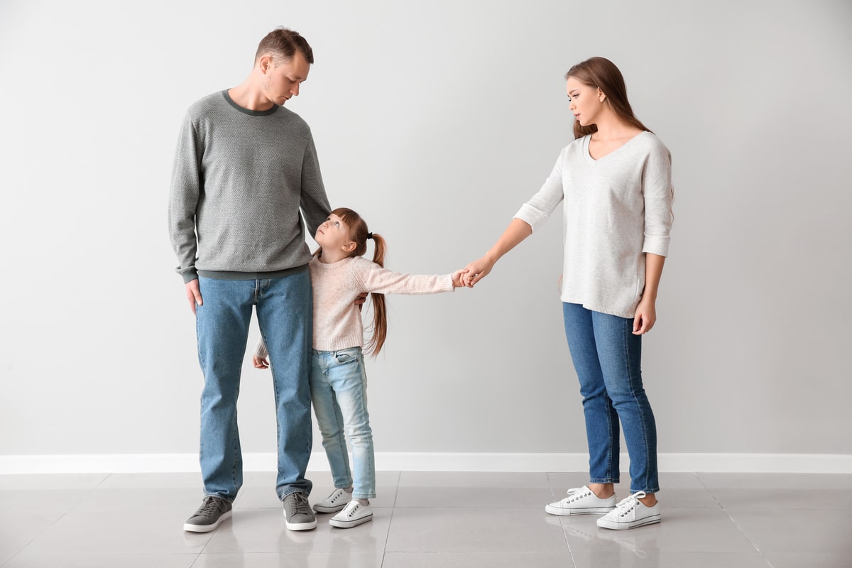 unhappy family after divorce against light wall