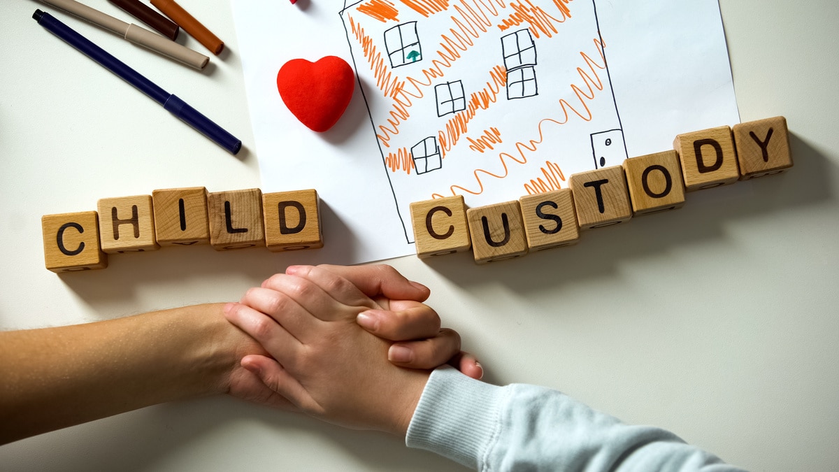 child custody phrase and toy heart on house picture, kid holding