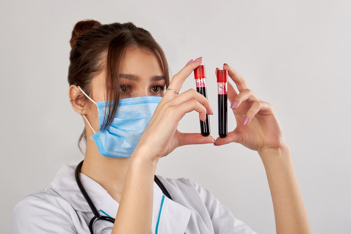 portrait of doctor with two blood test samples.