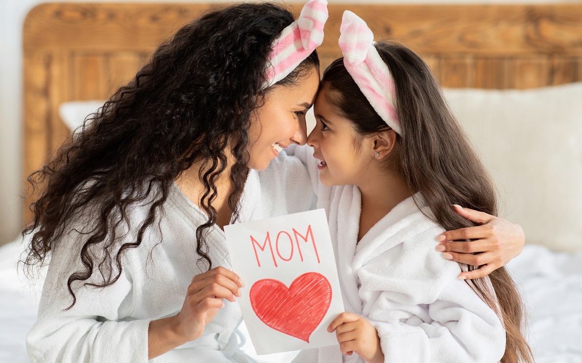 loving mother and daughter in bathrobes celebrating mother day