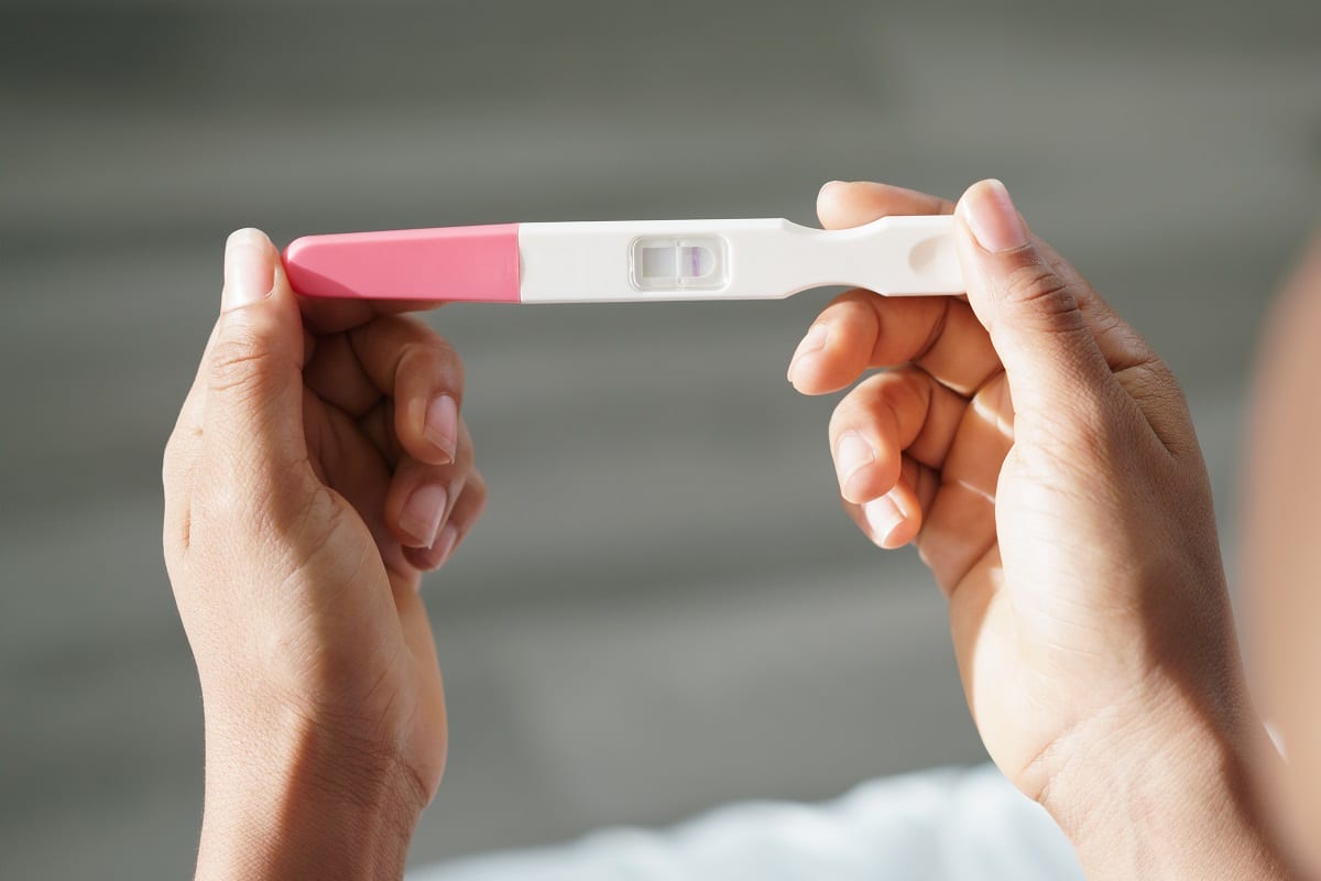 woman holding negative pregnancy test kit