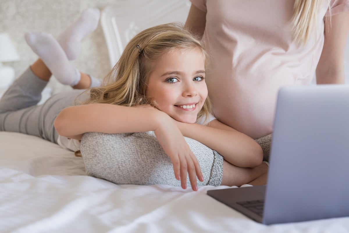 cropped image of smiling kid lying on mothers leg