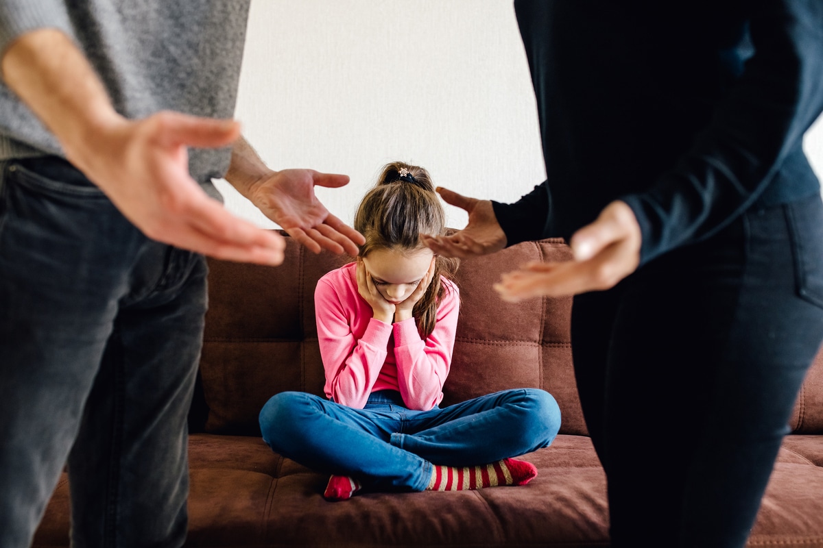 stressed little girl upset tired of parents fight.