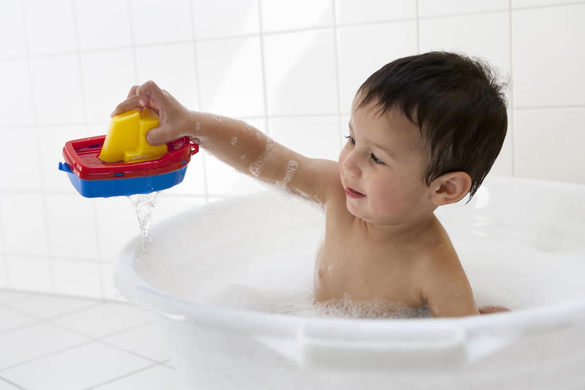 two year old boy playing in the bath tub