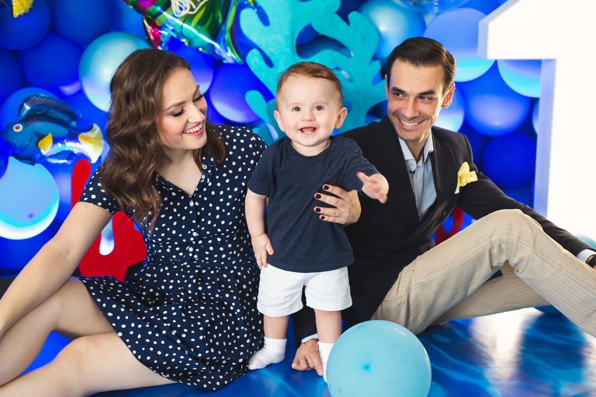 father, mother and son on the background of blue decor in the marine style at the holiday