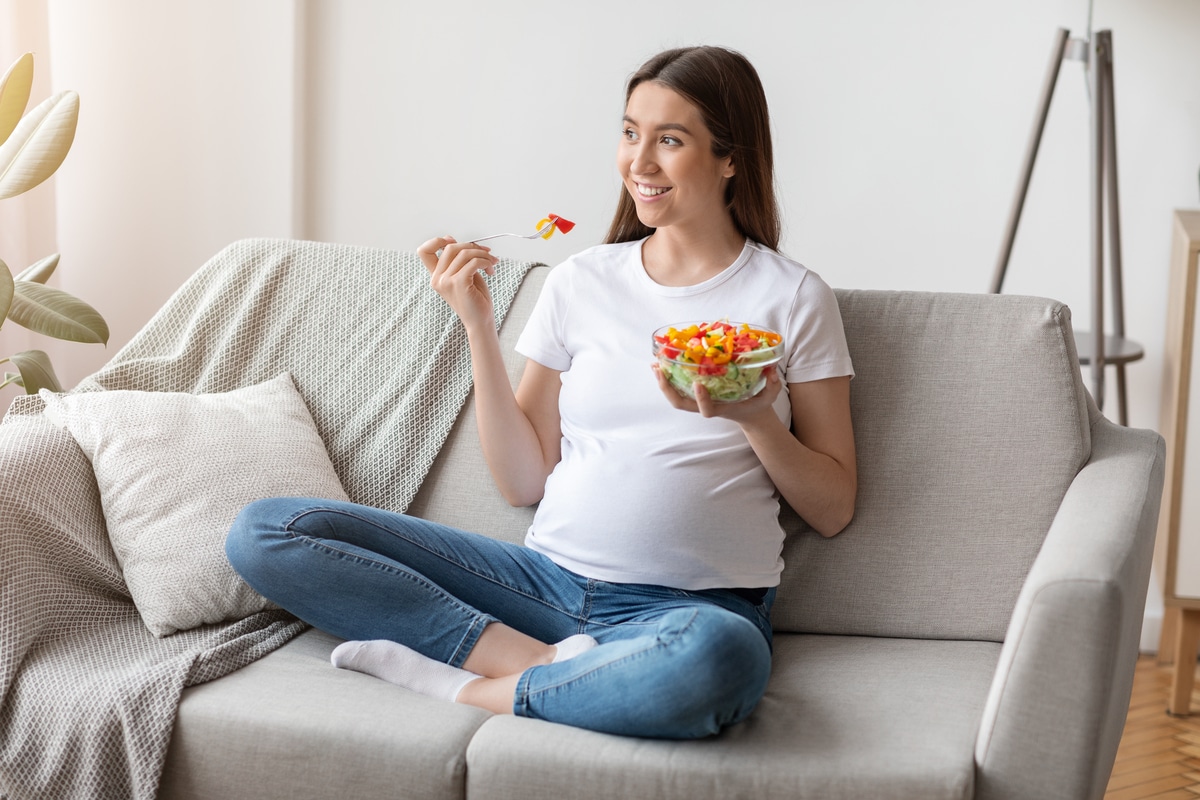 healthy diet during pregnancy. young expectant woman enjoying fresh vegetable salad