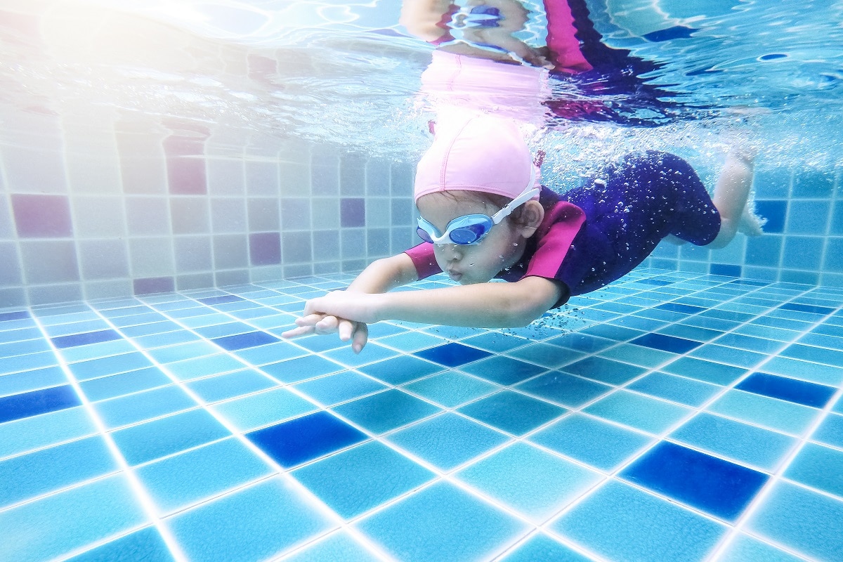 underwater young little cute girl is swimming in the swimming po