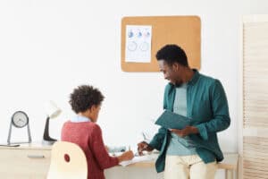 boy studying with teacher