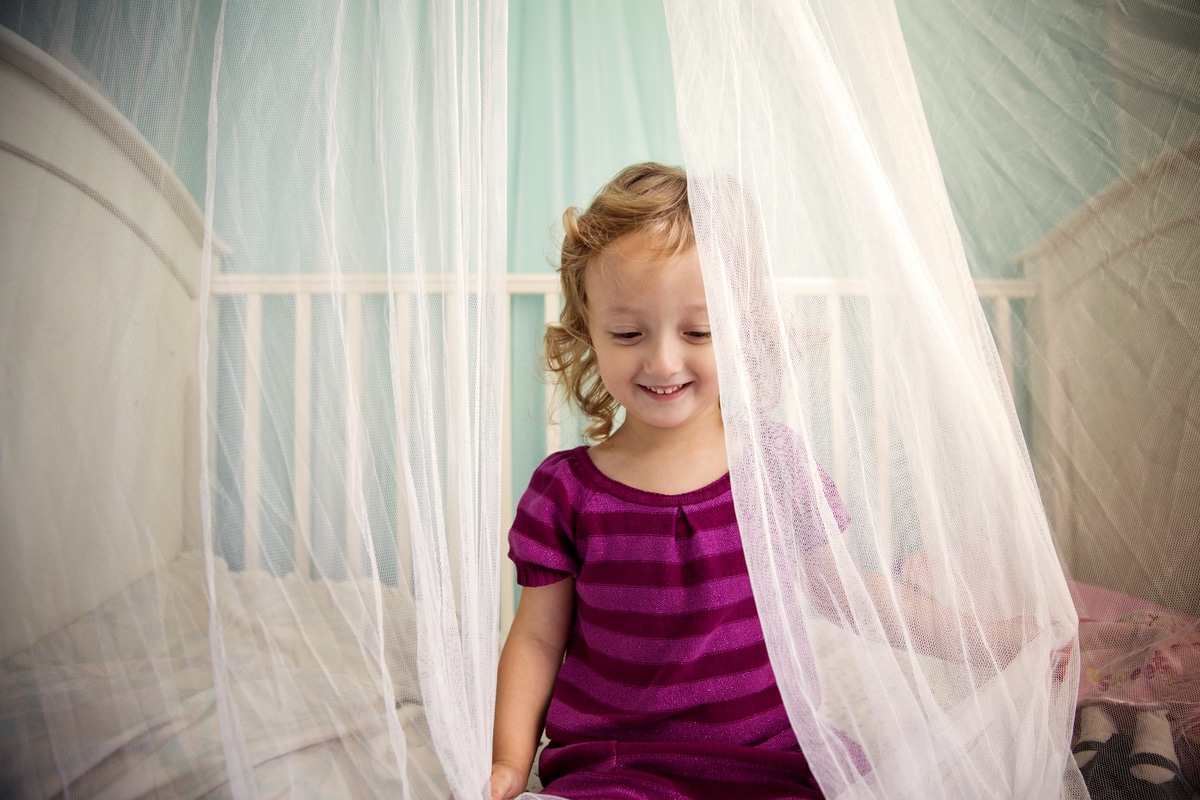 cute girl sitting in crib