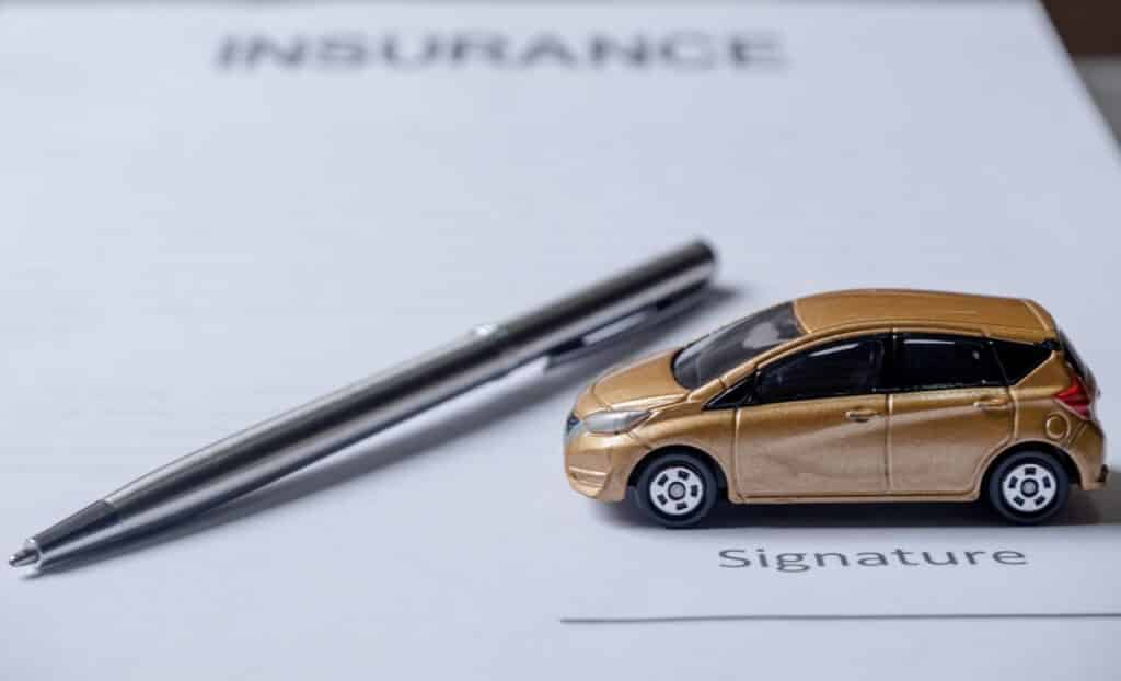 car and pen on insurance documents. car insurance concept