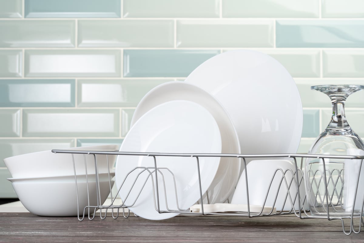 dish rack with clean dry dishes on kitchen counter