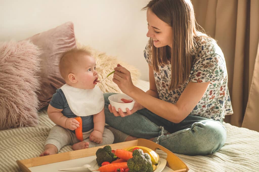 first solid food for young kid. fresh organic carrot for vegetable lunch. baby weaning.