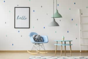 gray knot cushion on a blue rocking chair standing in a white ch
