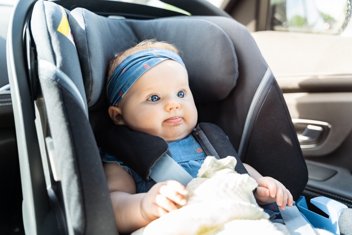 baby girl sitting in an infant car seat, safety travelling by ca