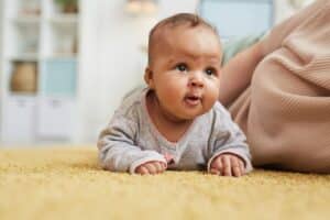cute mixed race baby crawling on floor