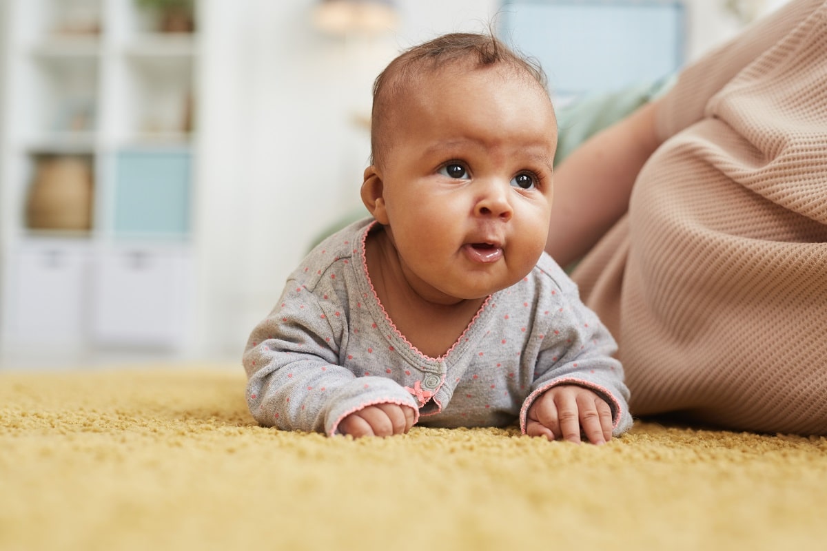 cute mixed race baby crawling on floor