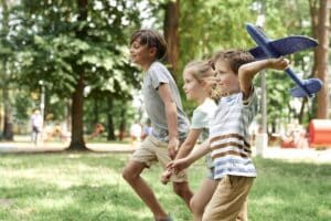 group of kids playing together with airplane toy