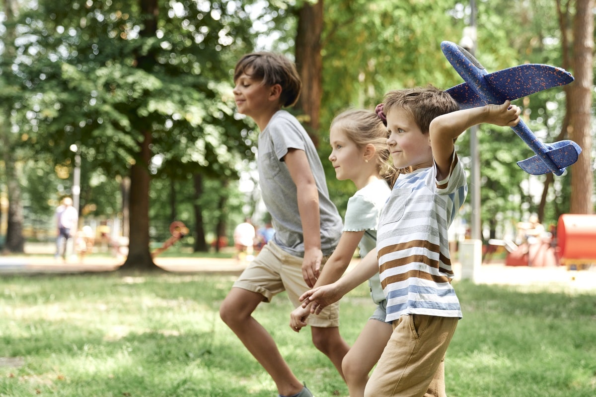 group of kids playing together with airplane toy