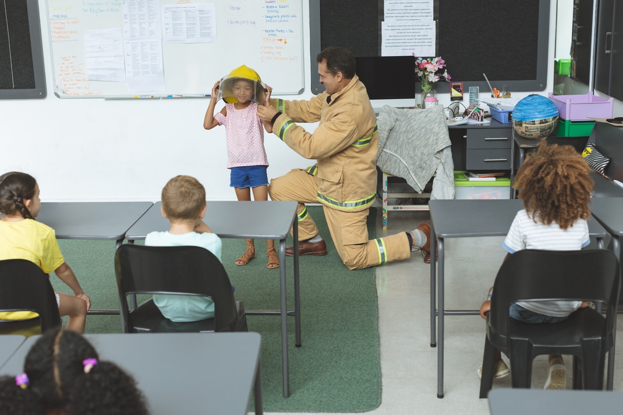 firefighter teaching to schoolgirl about fire safe 2021 08 28 16 45 31 utc(1)