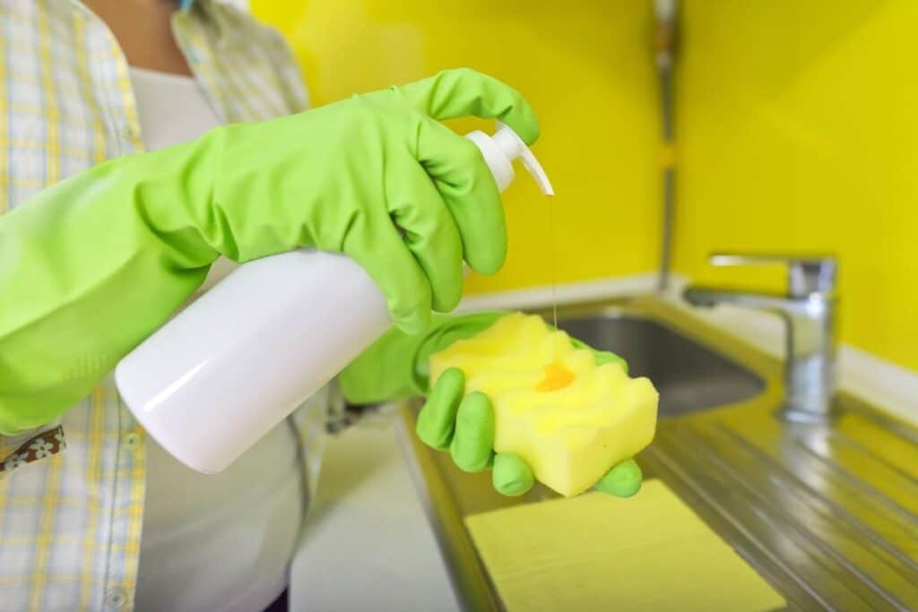 woman cleaning kitchen with sponge and bottle of d 2021 12 10 19 58 52 utc(1)(1)