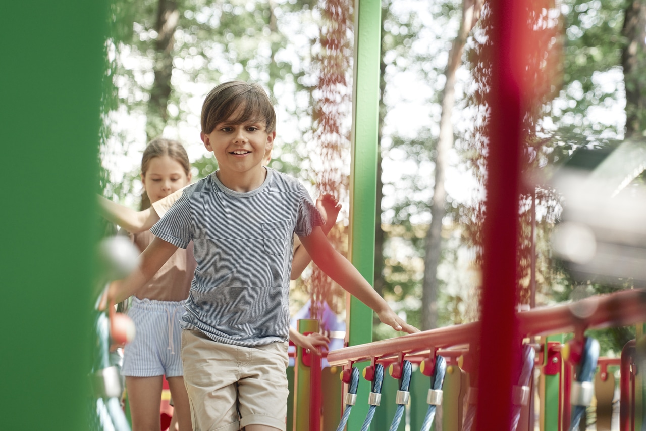 group of kids playing at the playground in summer day