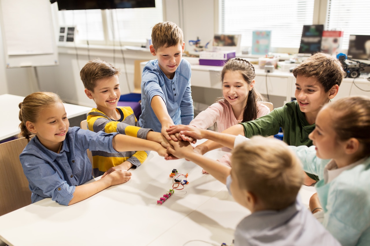 happy children holding hands at robotics school