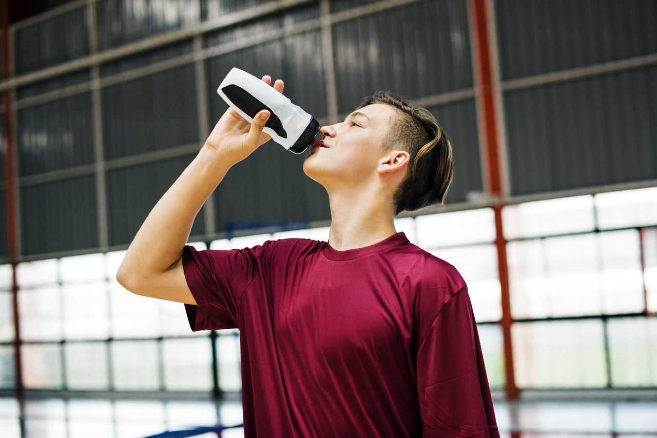 young sporty man drinking sporty drink or water