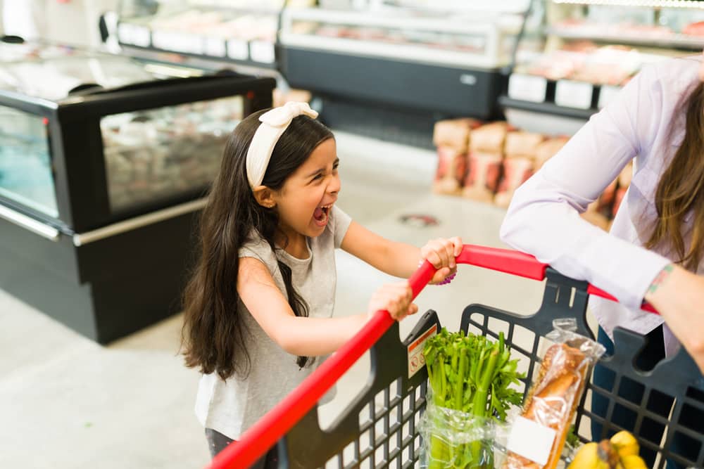 annoyed young daughter shouting in the store