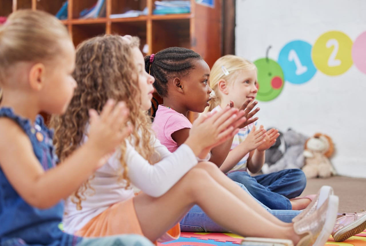 learning made fun. shot of children clapping hands while sitting in class