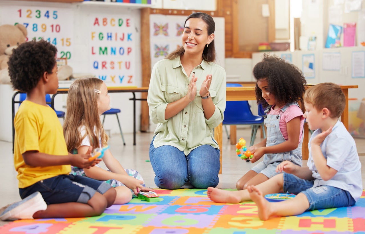 shot of a teacher singing with her preschool children.