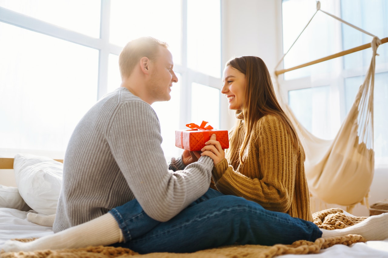 valentine's day concept. exchange of gifts. young couple at home celebrating valentine's day.