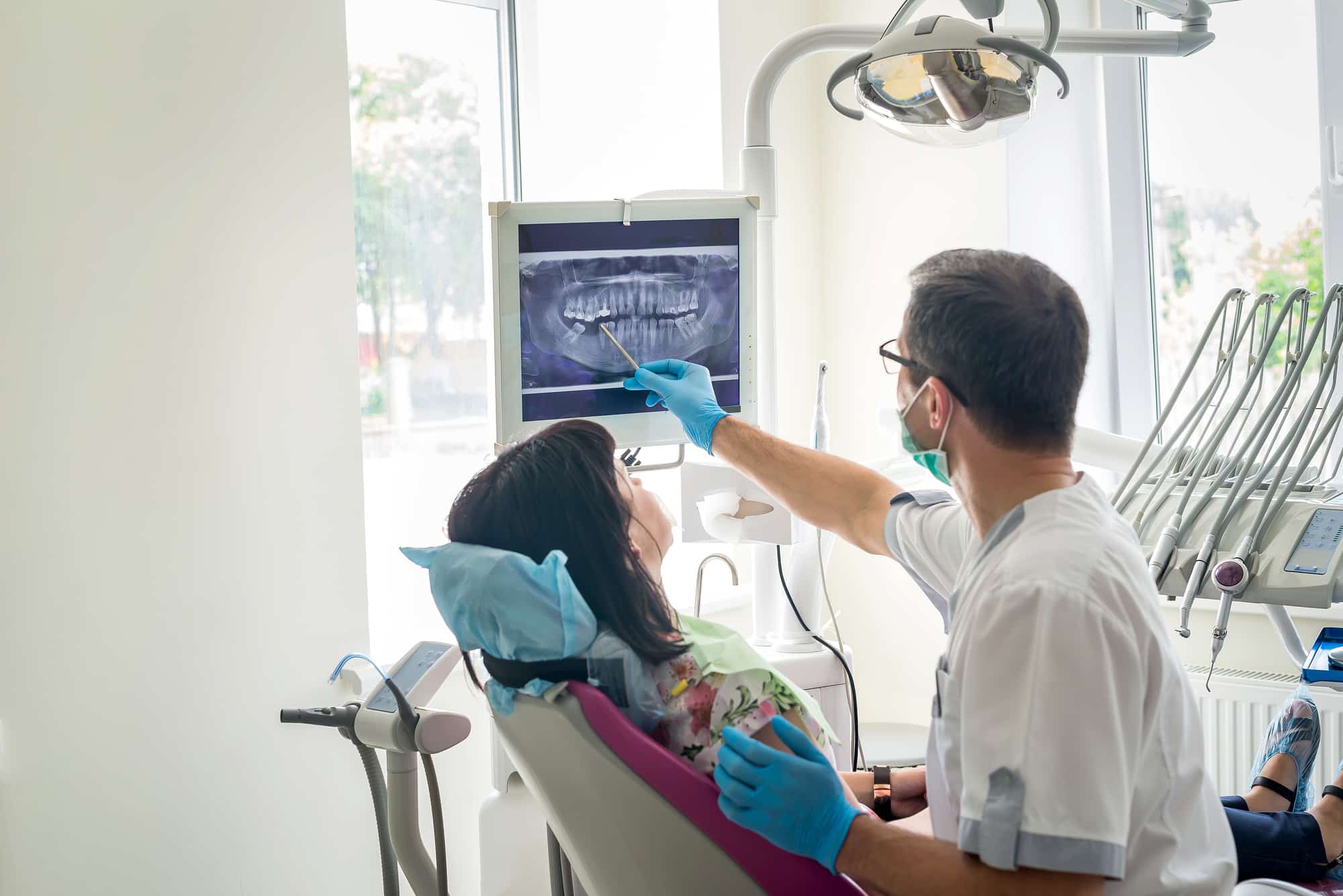 doctor dentist showing patient's teeth on x ray