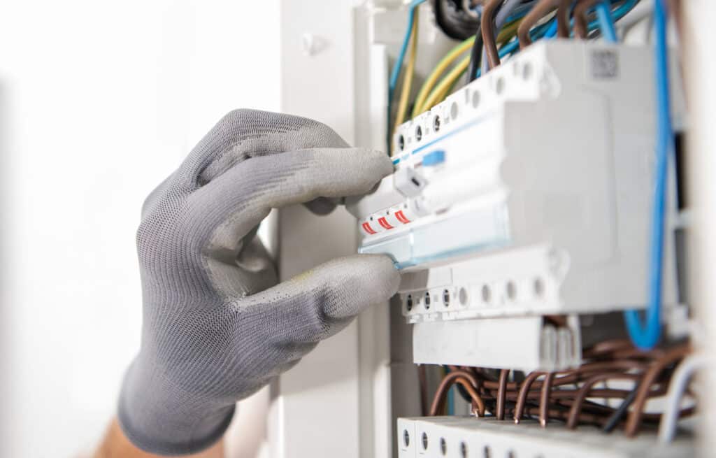 electrician testing fuses in the electric box