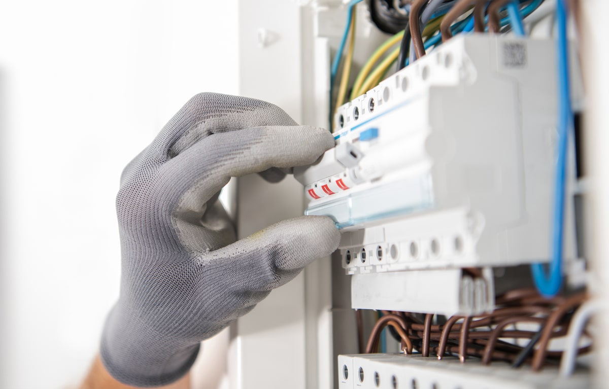 electrician testing fuses in the electric box