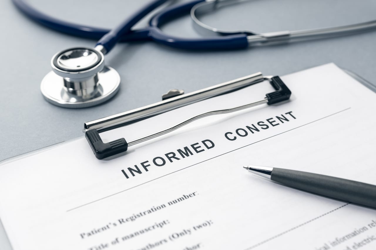 informed consent form and stethoscope on desk