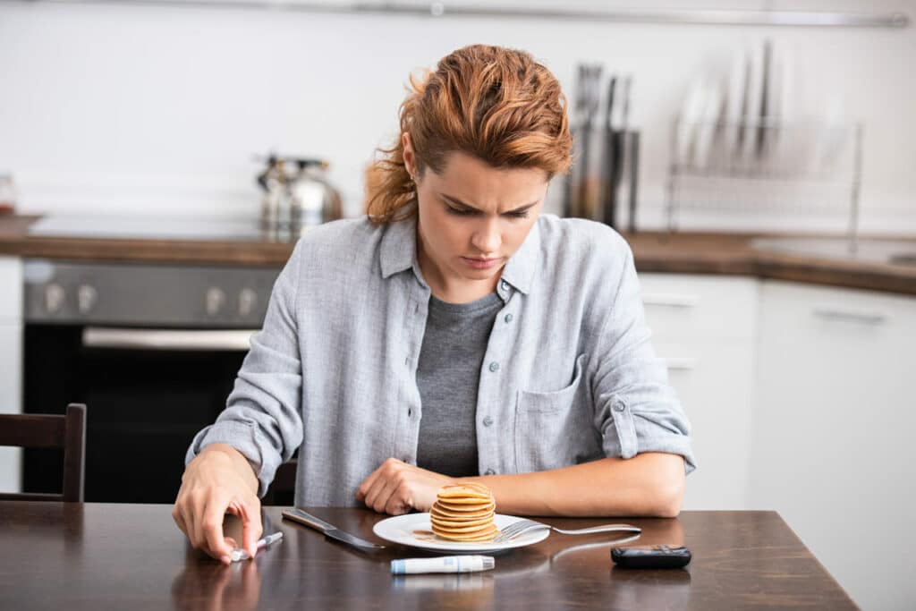 woman with diabetes looking at sweet pancakes 2023 05 11 23 49 54 utc