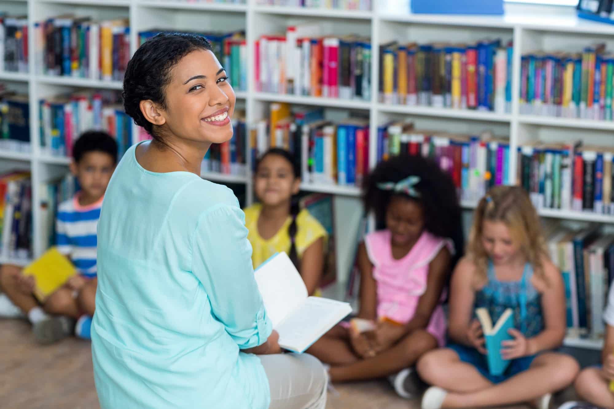 happy mixed race female teacher with children