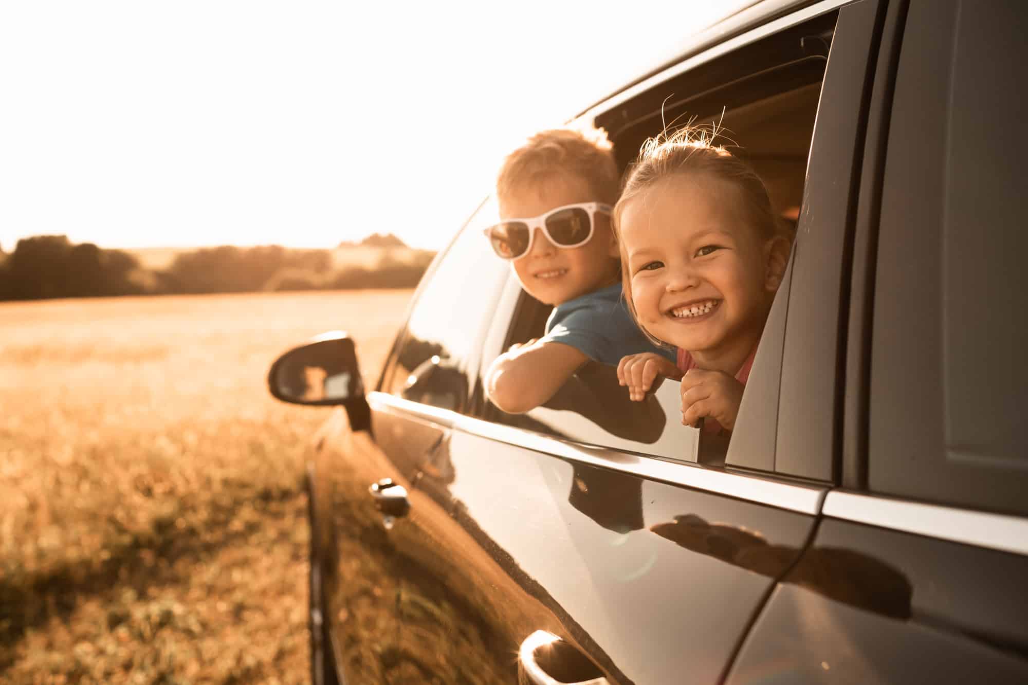 portrait of happy little boy and girl in car. family road trip,