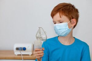 a child in a medical mask holds a nebulizer in his 2022 11 01 02 15 39 utc(1)(1)