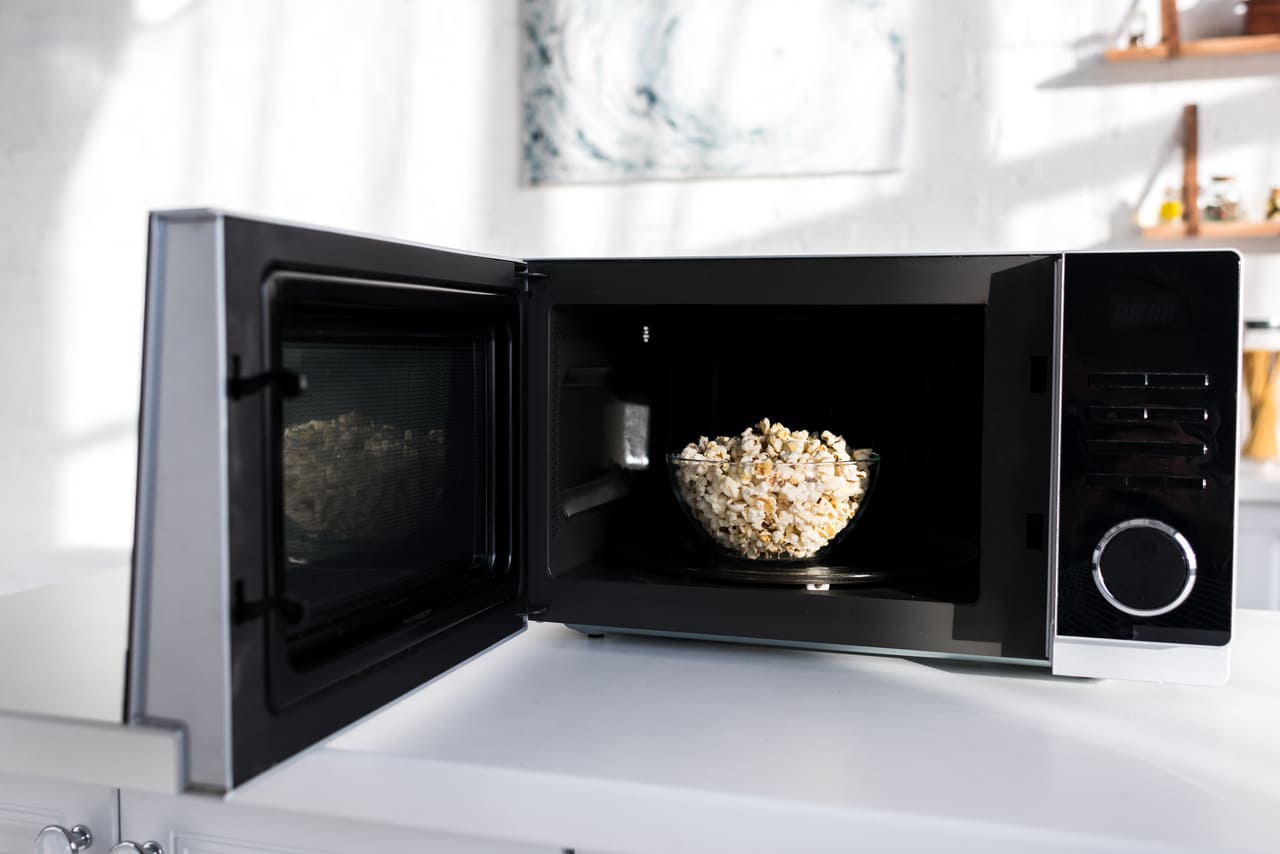 bowl with popcorn in opened microwave in kitchen 2022 12 16 19 01 40 utc