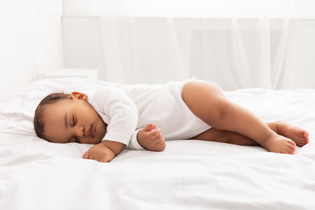 cute little baby sleeping lying on side in bedroom indoors