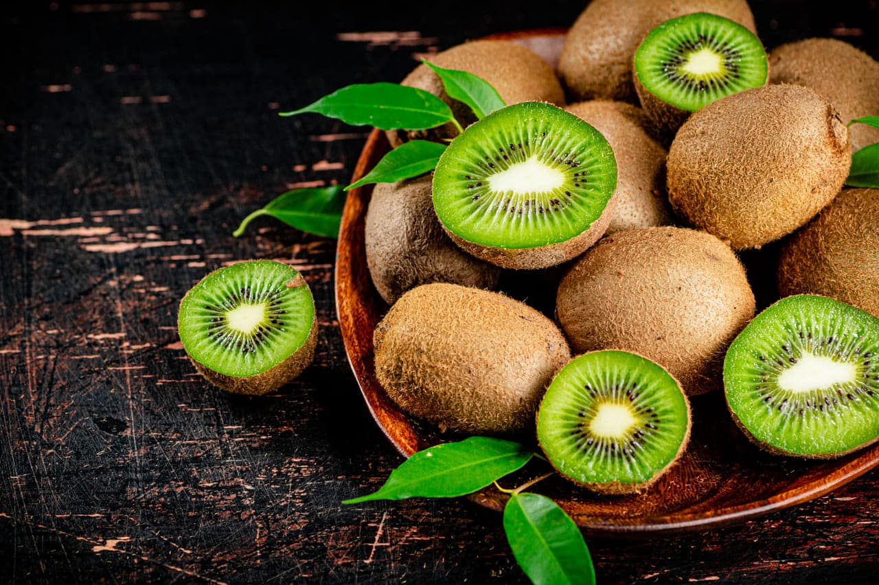 fresh kiwi with leaves on a wooden plate 2022 01 12 00 49 25 utc