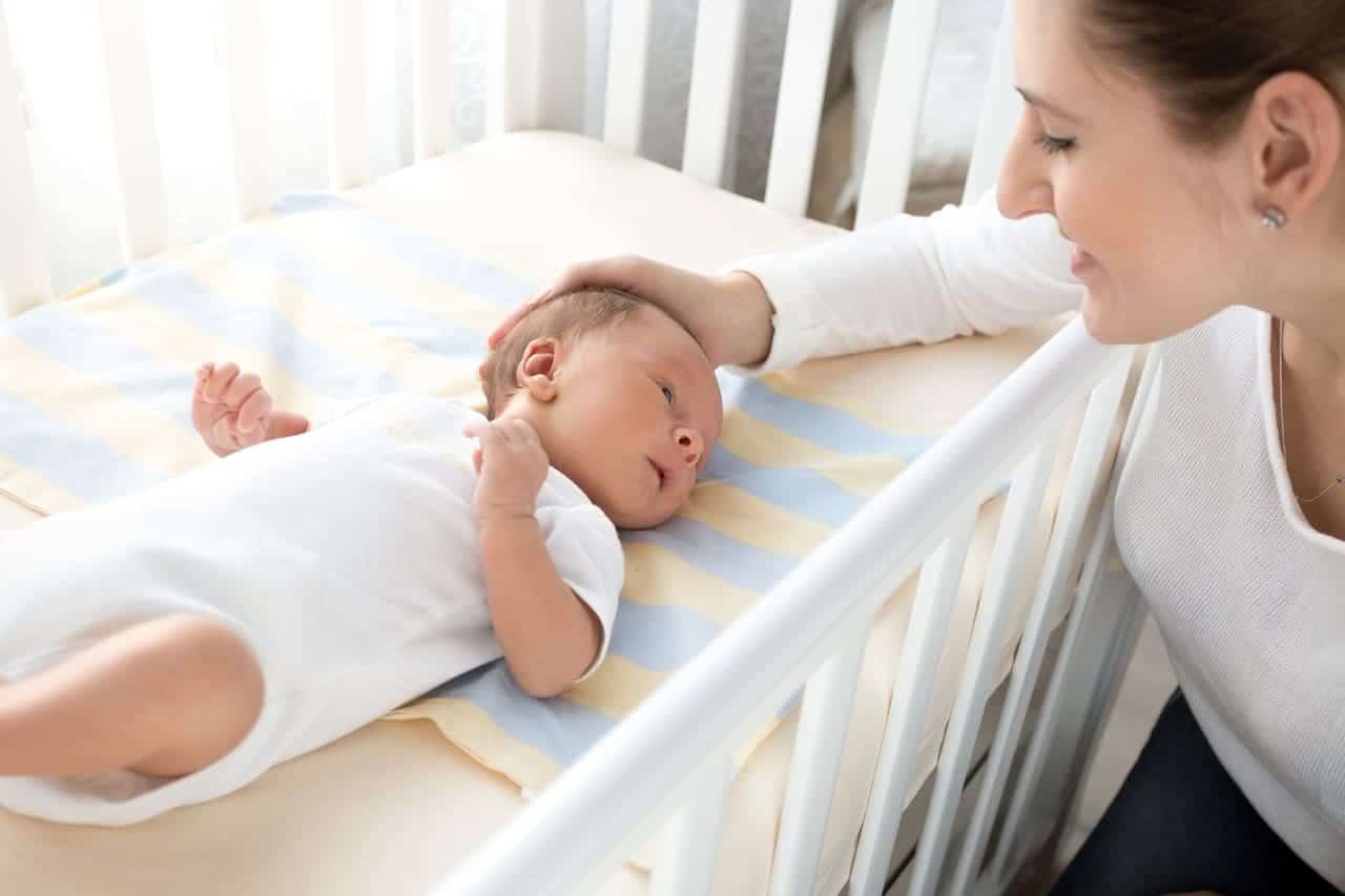 happy smiling mother caressing her baby lying in c 2021 12 14 00 25 42 utc