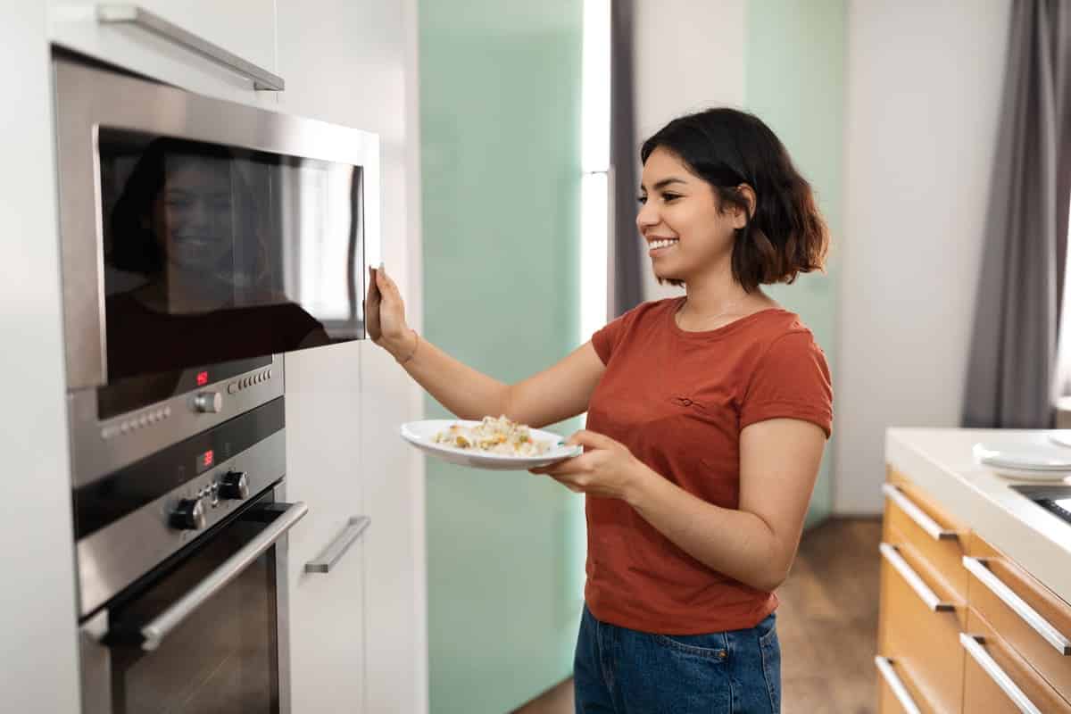 happy young arab woman warming food in microwave i 2023 03 08 19 58 04 utc(1)(1)