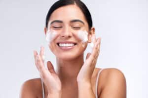 studio shot of a beautiful young woman washing her face.