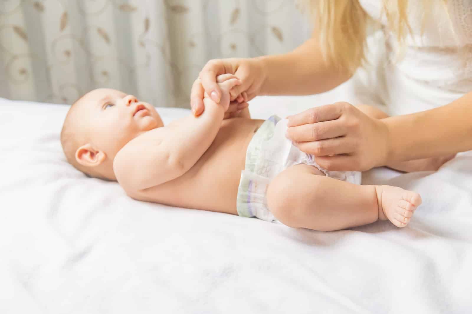 the mother changes the baby's diaper. selective focus.