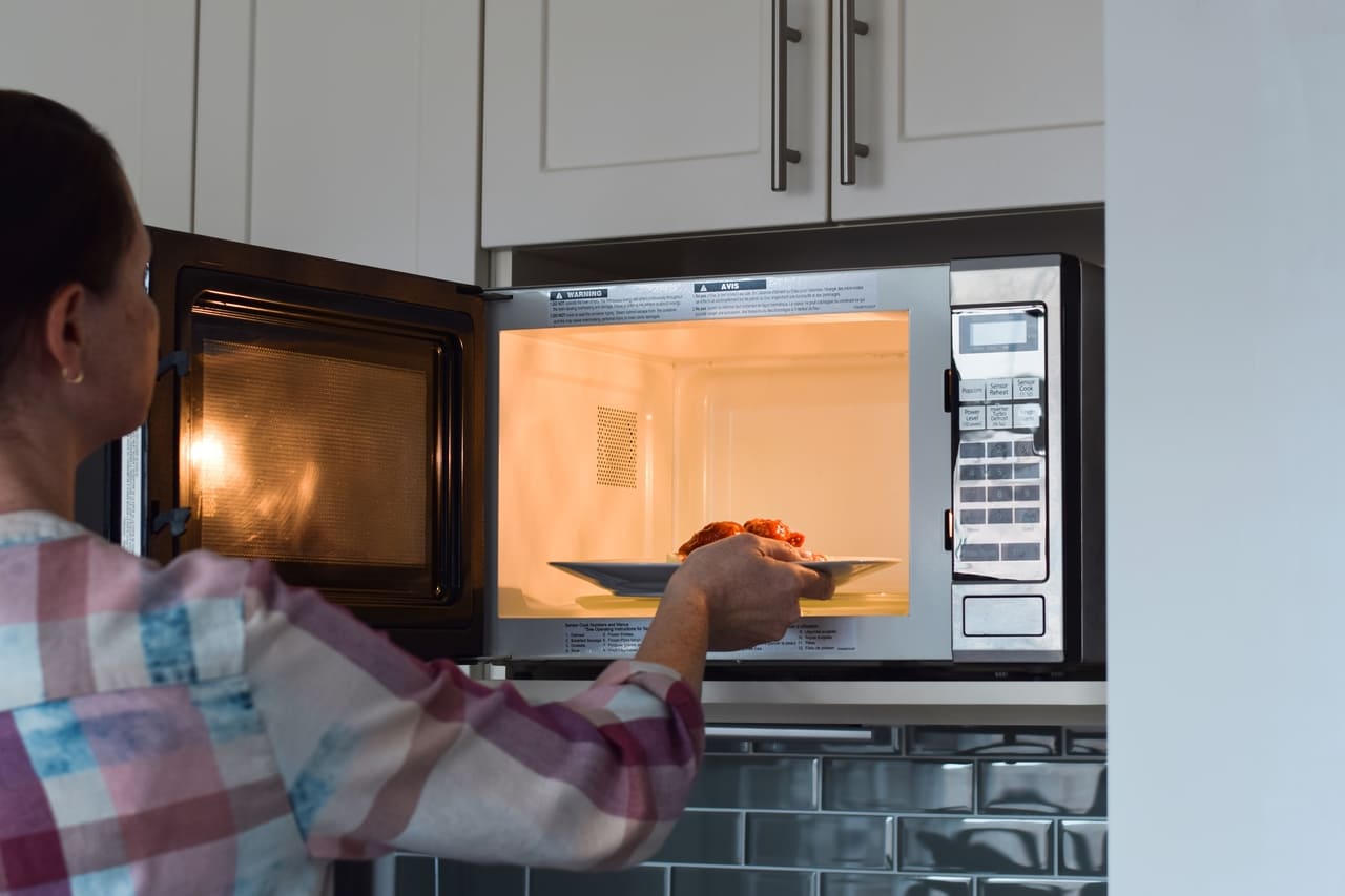 woman placing plate with food into microwave to wa 2022 11 14 06 35 52 utc